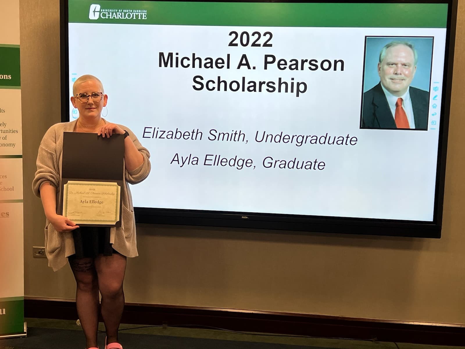Ayla Elledge, graduate winner of the Michael A. Pearson Scholarship, standing with her award.